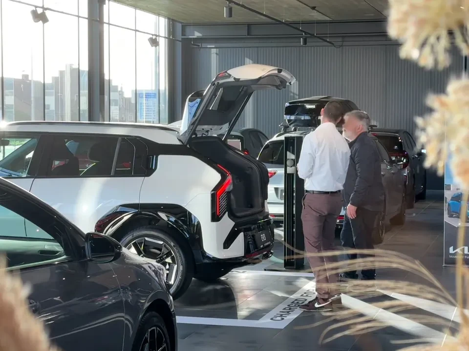 Verkoper toont een klant de koffer van de Kia EV9